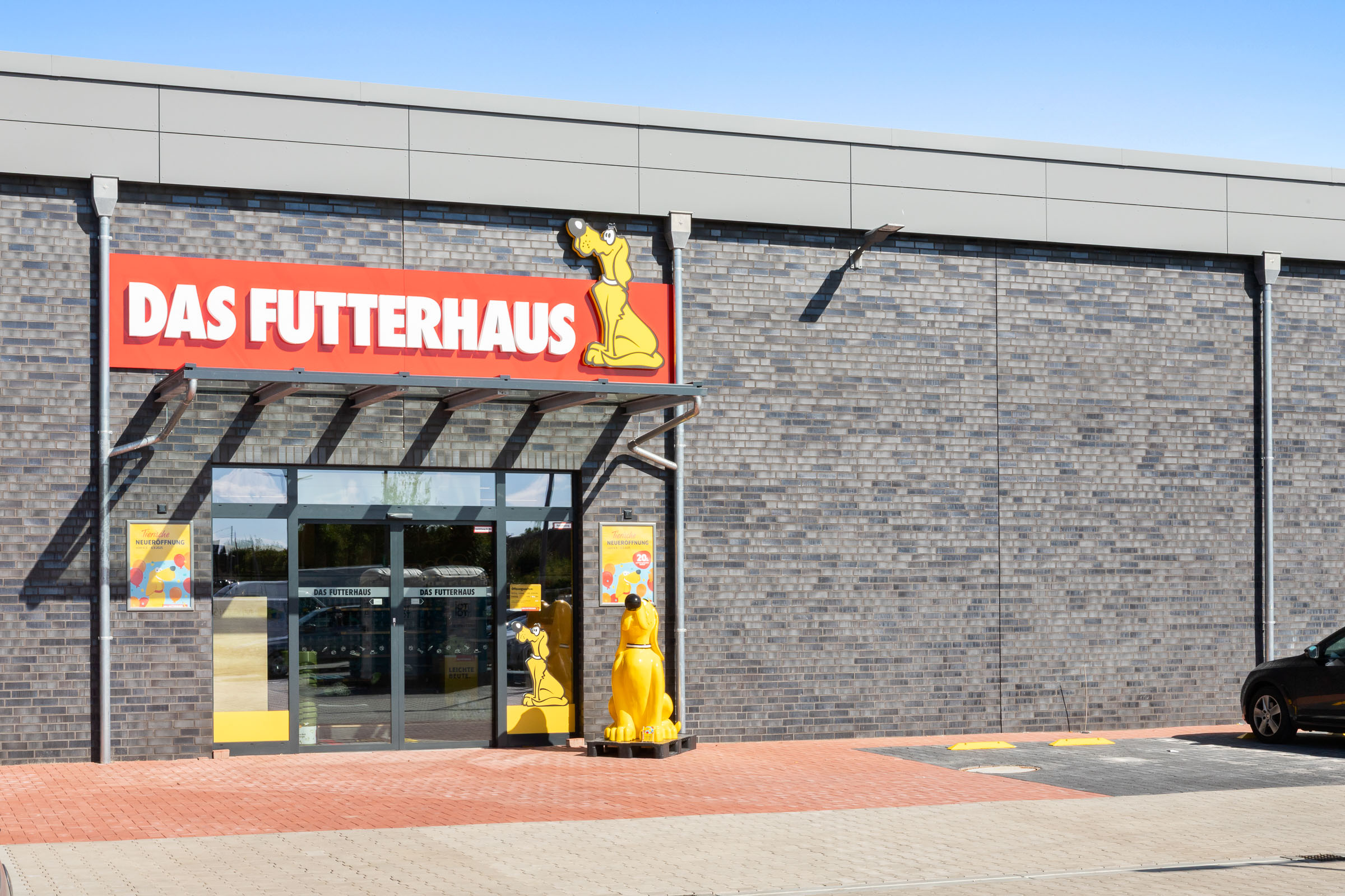 Eingang des FUTTERHAUS Wolgast mit dem gelben Hund davor